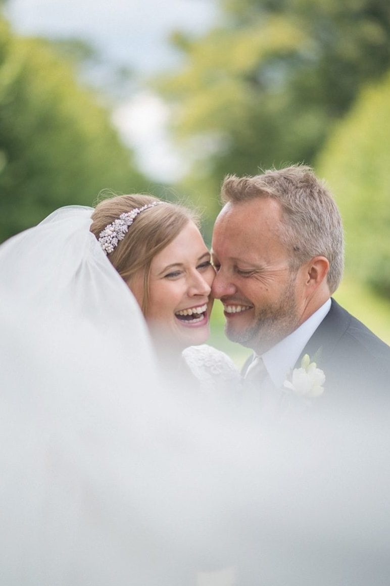 Bride and Groom laughing with each other at their Coworth Park Wedding