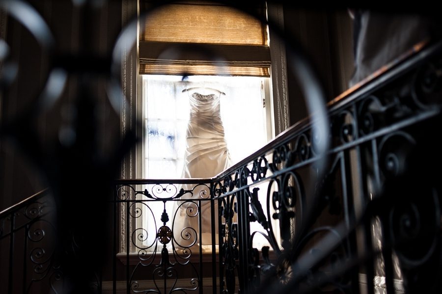 Wedding dress hanging in a window at Great Fosters gallery and staircase