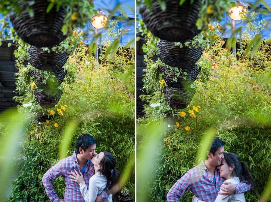 Couple kiss and hug surrounded by planters and greenery