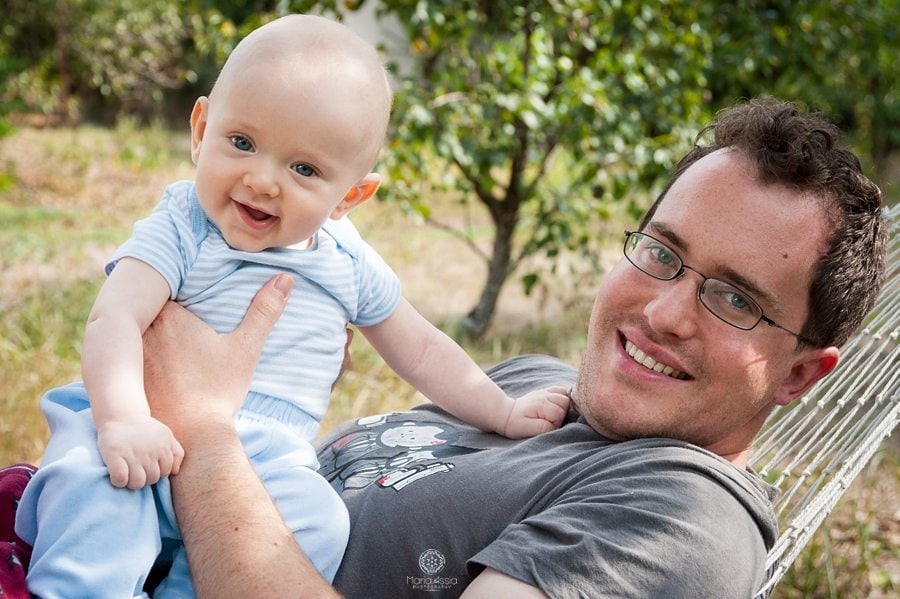 baby and his father playing in a hammock