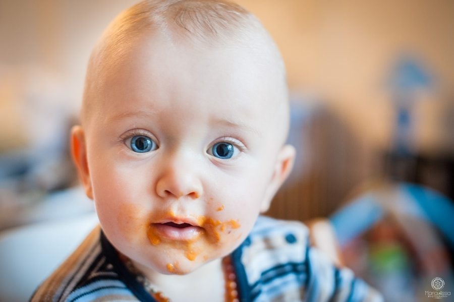 blue eyed baby with pasta sauce on his face