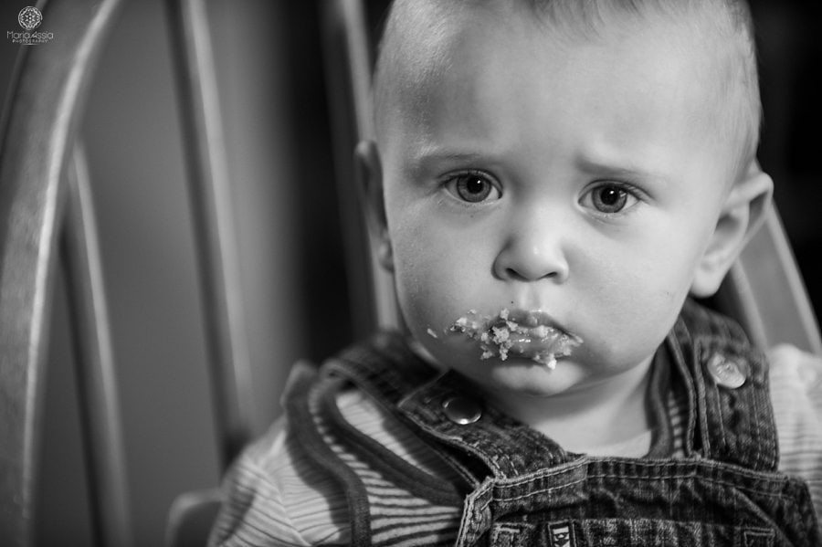 documentary family photograph of a toddler eating cake 