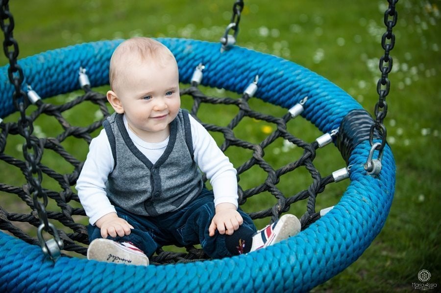 toddler swinging on a rope swing on the playground