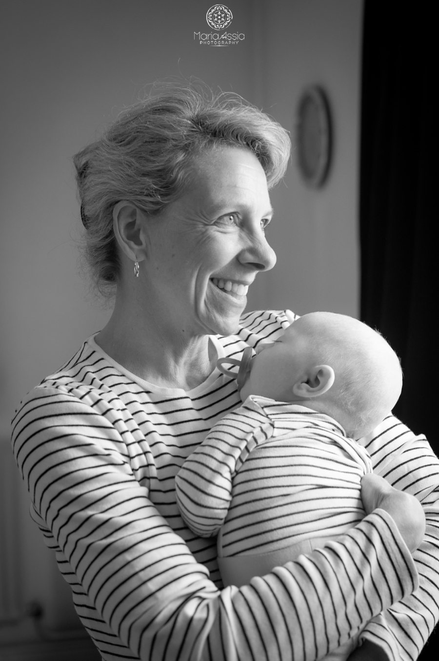 grandmother holding her grandson baby both wearing stripes