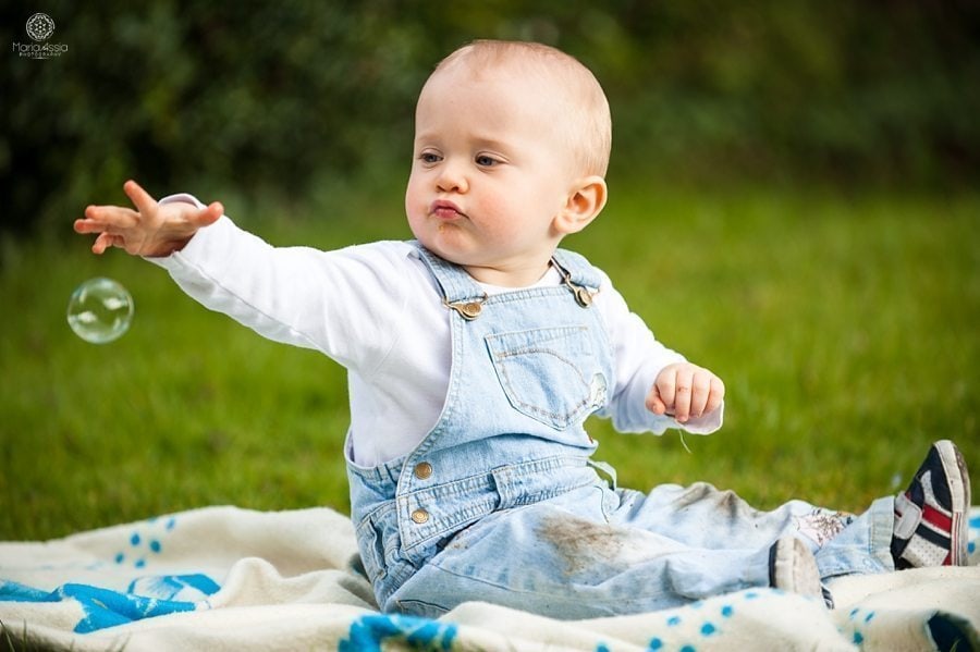 documentary family photography of a toddler playing with bubbles