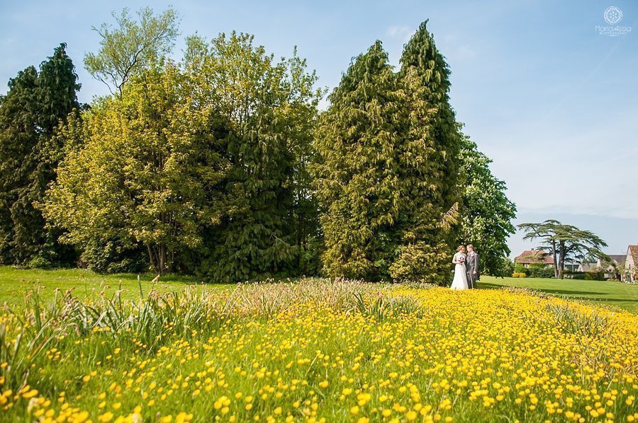 Summer wedding at Billesley Manor Hotel couple shoot in a field of yellow buttercups