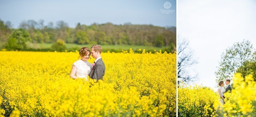 Bride and groom standing in rapeseed field at their Billesley Manor Hotel Fuchsia Spring Wedding