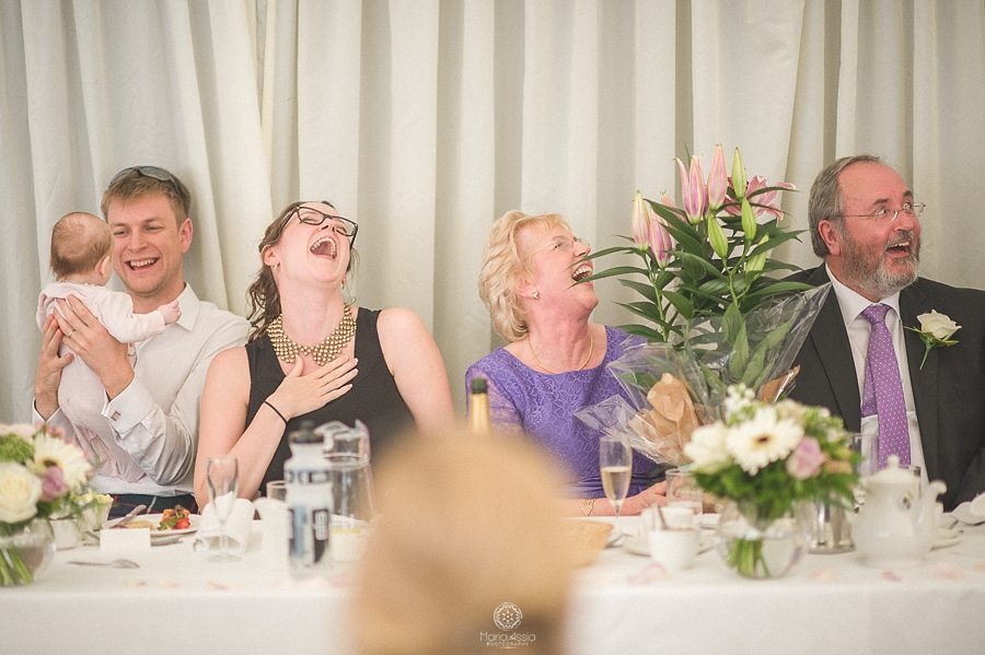 Guests laughing at wedding speeches at Birtsmorton Court Navy Blue Wedding - Maria Assia Photography