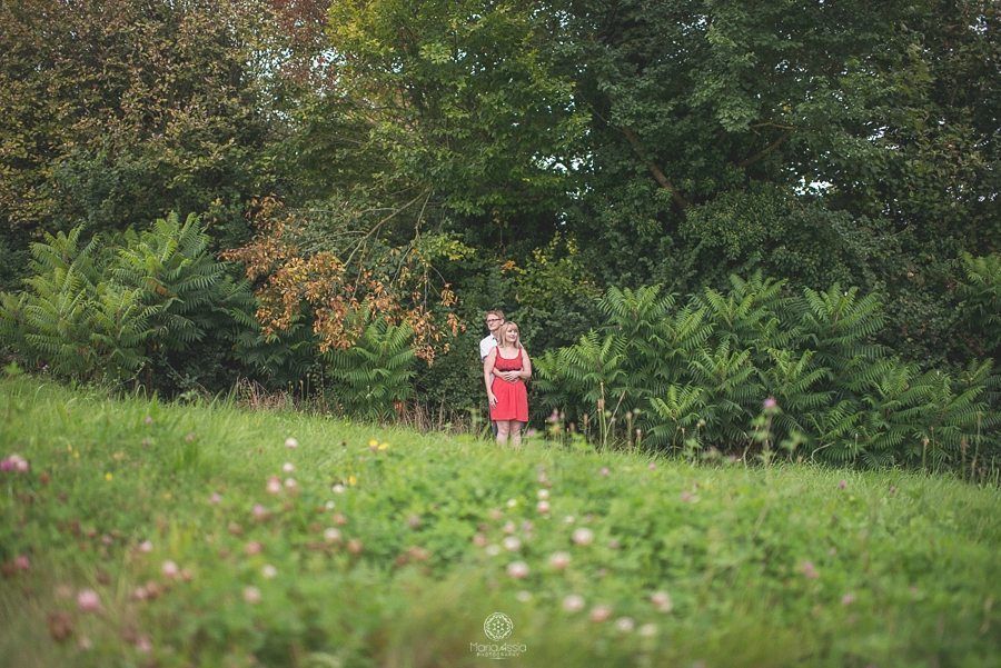 Engaged couple standing in Eynsford field overlooking the Kent Downs