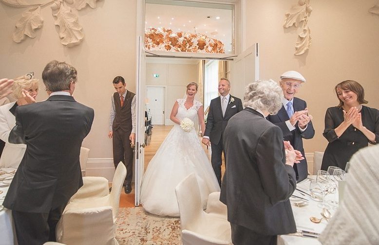 Guests cheer as the Bride and groom enter the Oak Room at Coworth Park