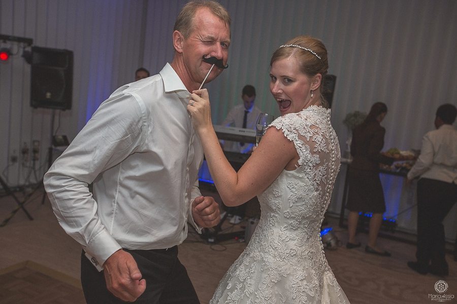 Bride dances with her father and holds up a fake moustache 