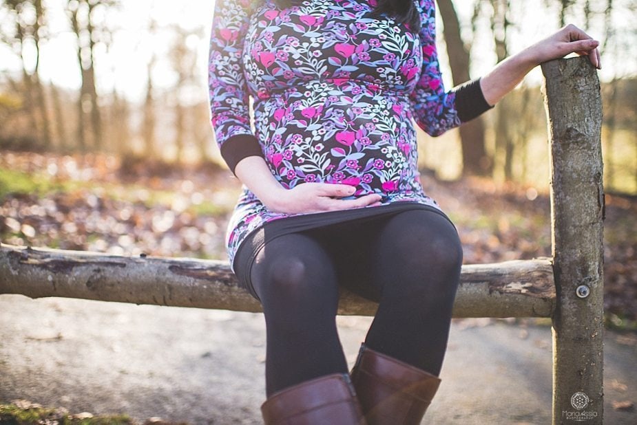 A pregnant girl holding her baby bump at Knole Park