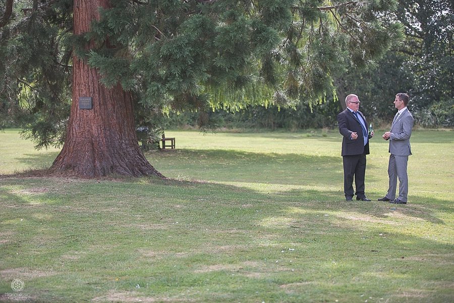 Wedding guests standing and chatting under a tree