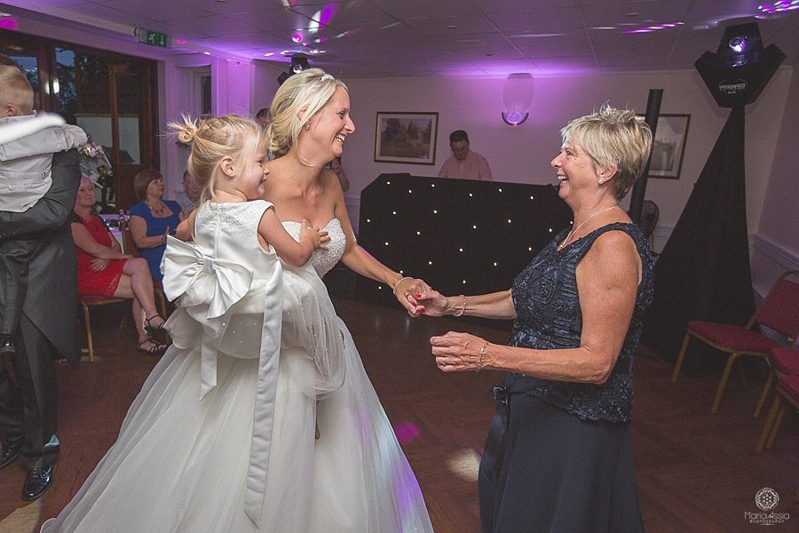 Bride dancing with her mother and daughter