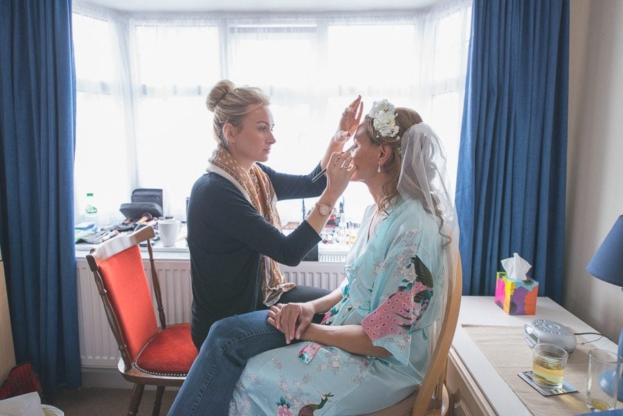 Bride's make up being done for her Shustoke Farm Barn wedding