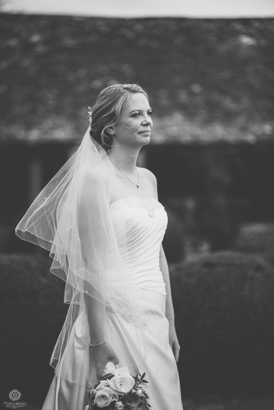 Bride looking over the gardens at her Caswell House purple themed autumn wedding