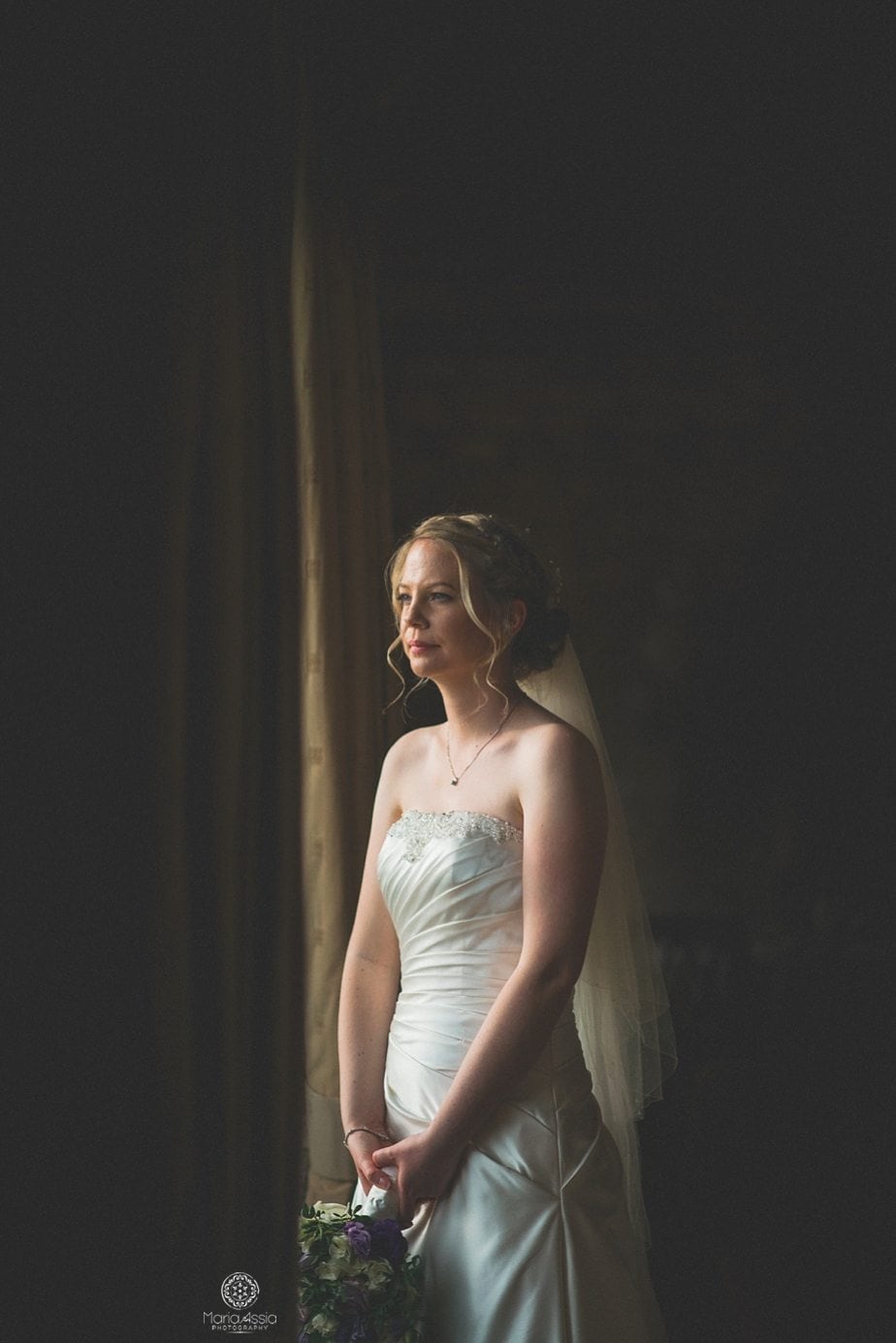 Bride looking out of the window at Caswell House Purple themed autumn wedding