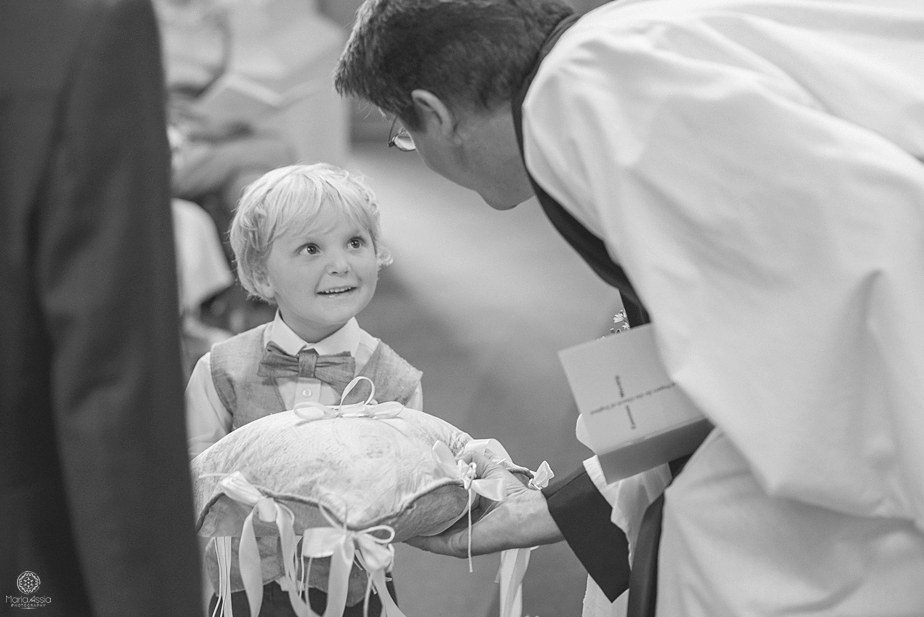 Vicar taking the wedding rings from a little boy ring bearer