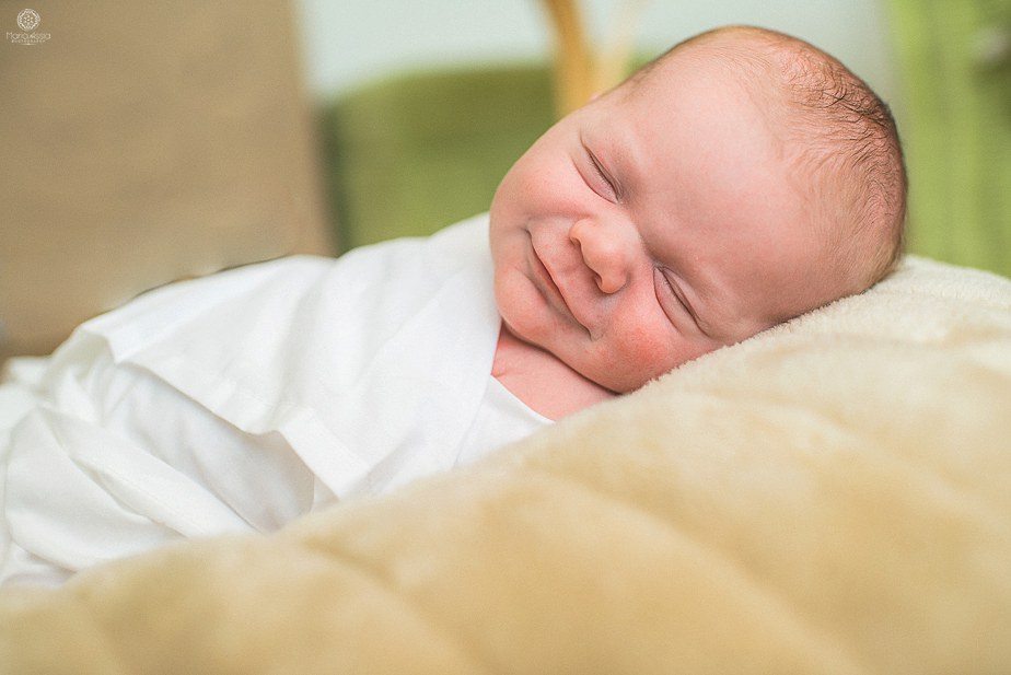 a smiling newborn baby at a Sevenoaks Newborn Shoot