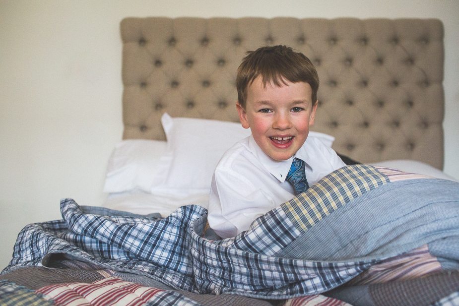 Little boy hiding under the covers