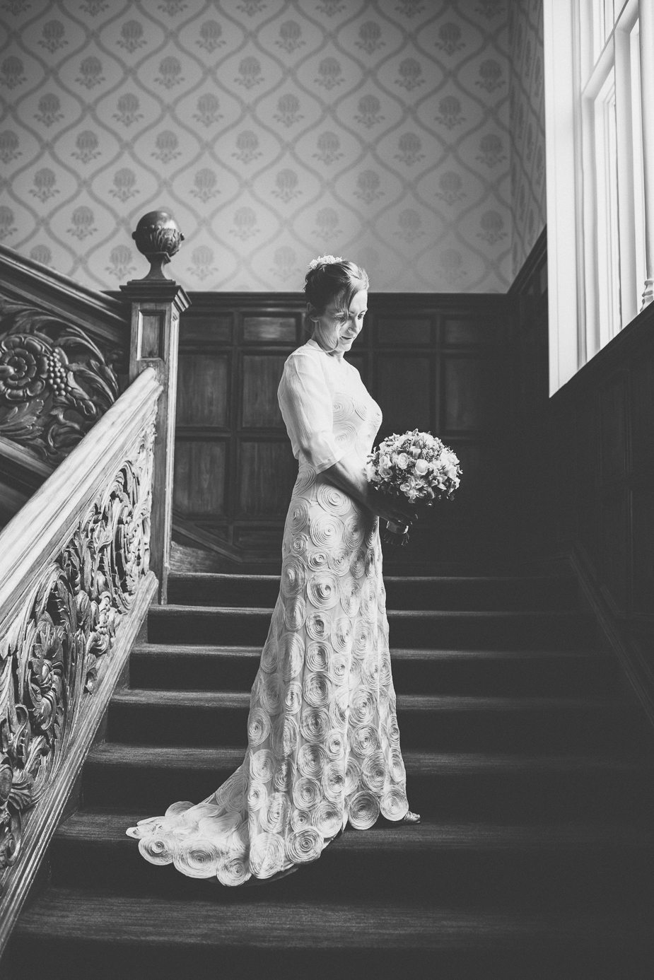 A bride standing on the grand staircase at Warren House