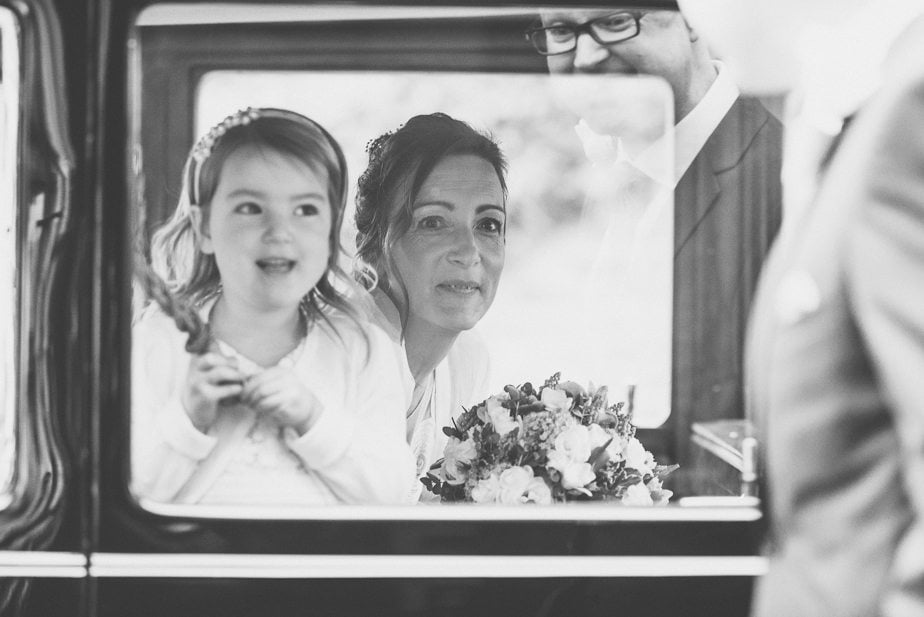 A groom welcoming his bride and daughter at the church