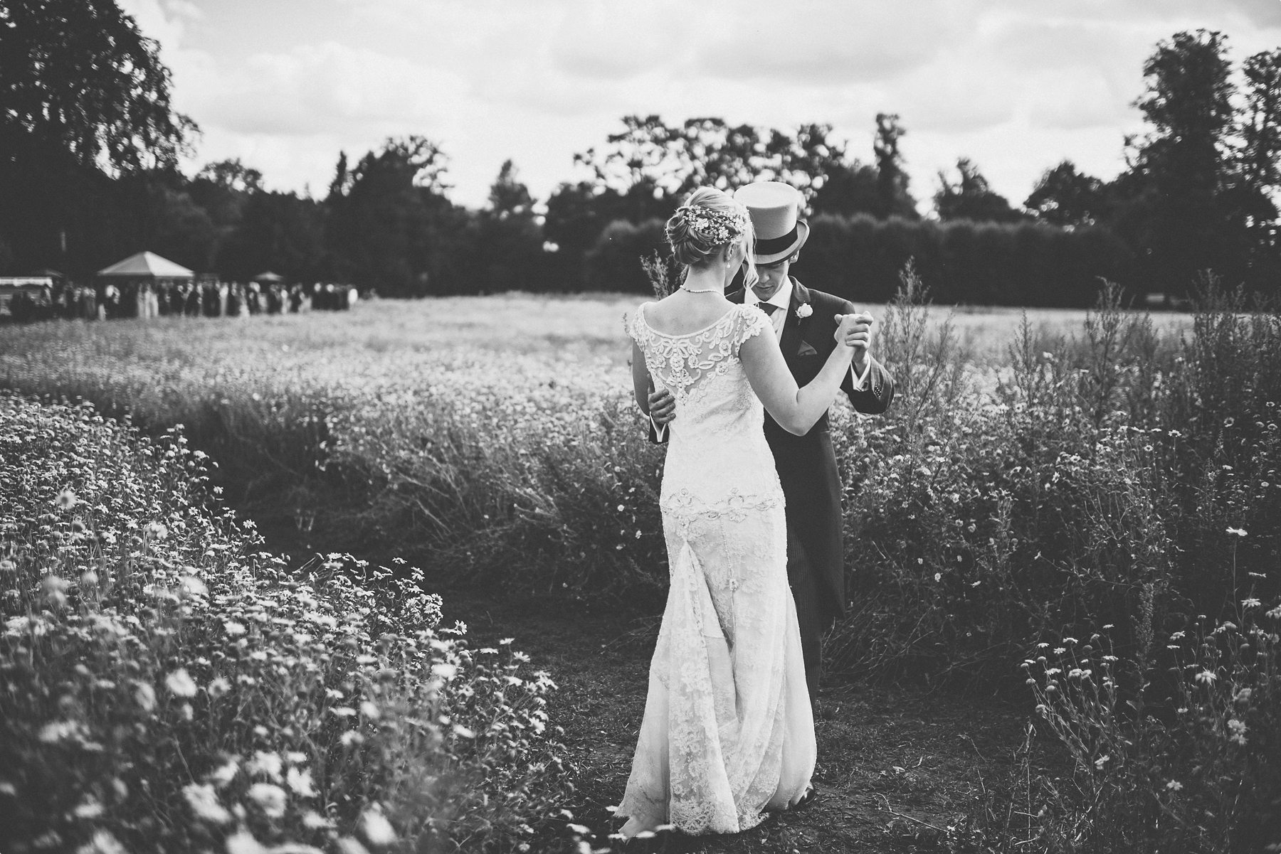 bride and groom practicing their first dance at Coworth Park wild flower meadow