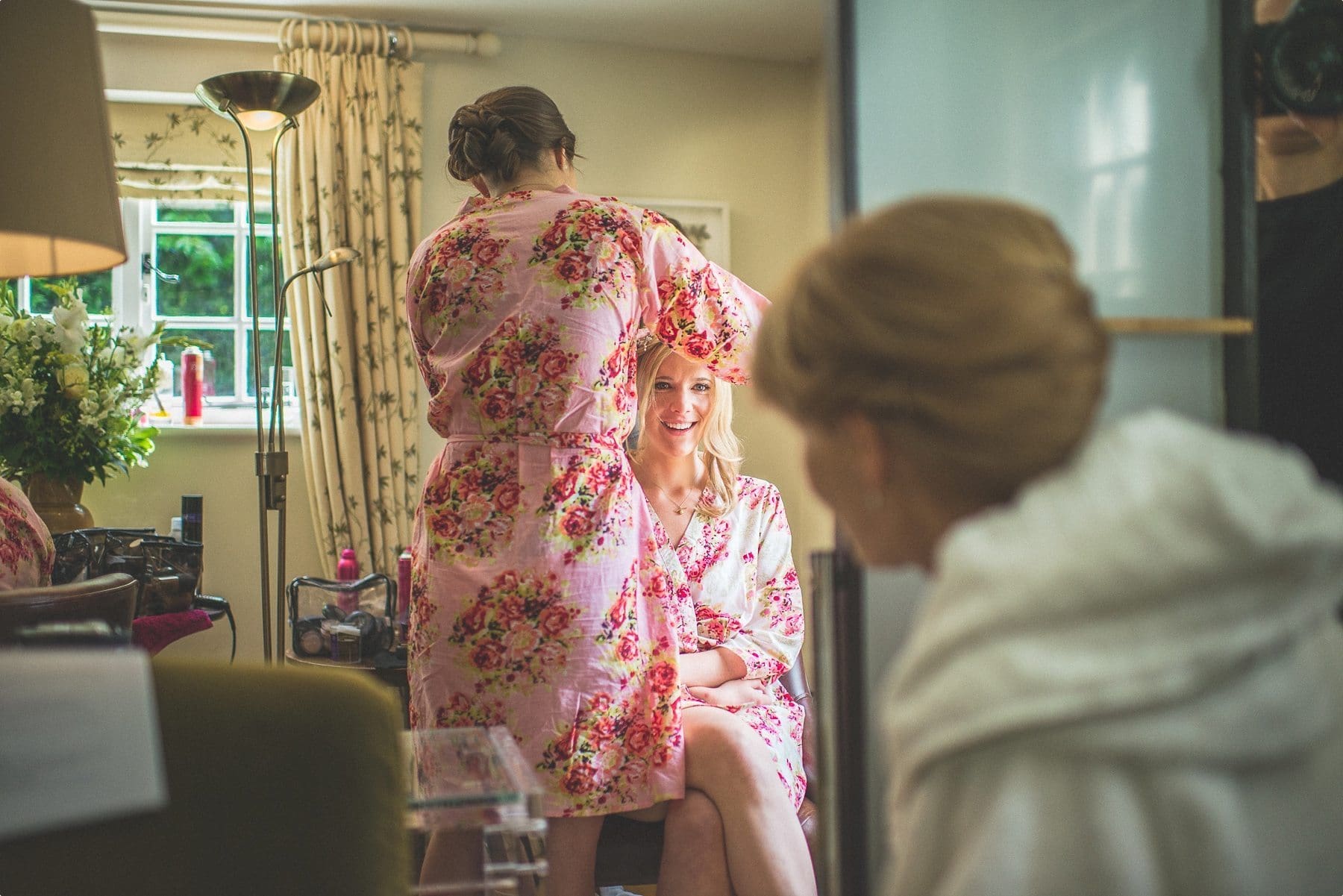 bride and mum exchanging a glance as they prepare for her Coworth Park barn summer wedding