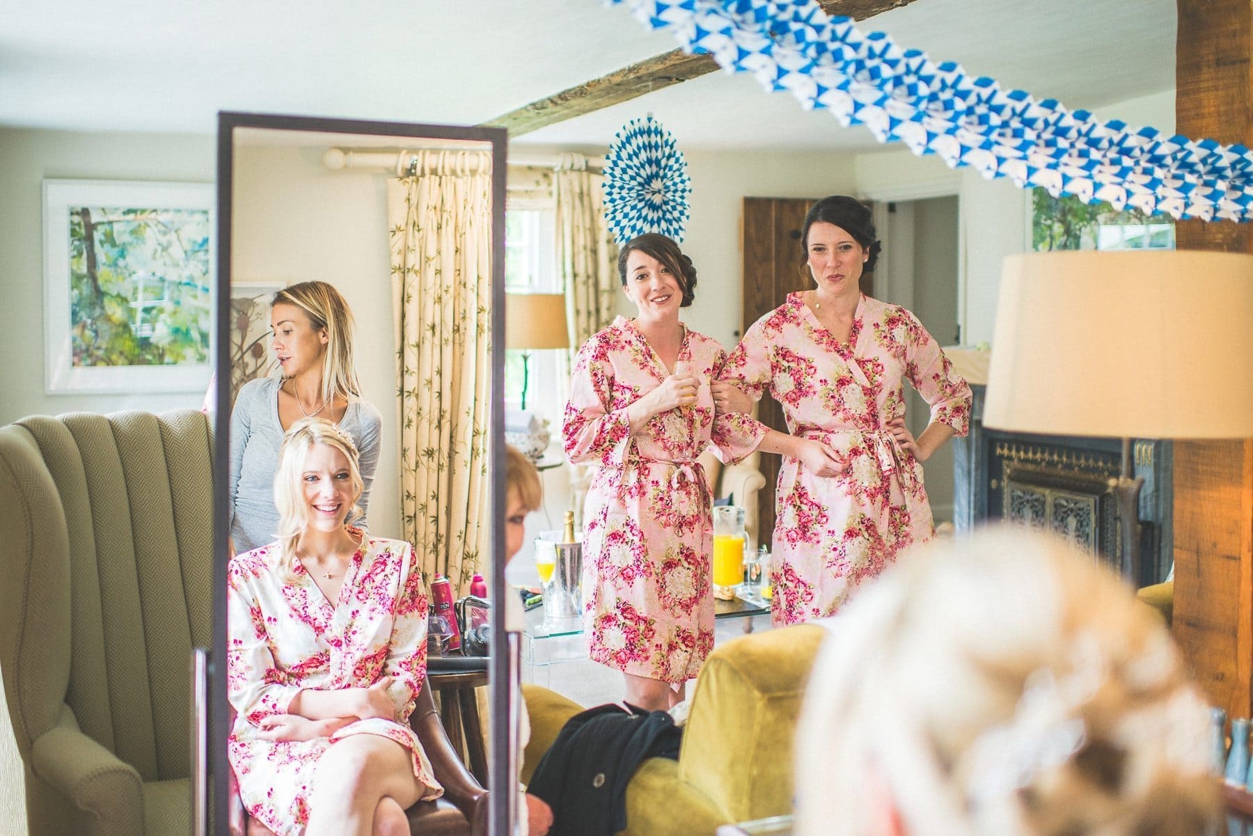 bridesmaids looking at the bride and the bride's reflection looking at them at the dower house at coworth park barn