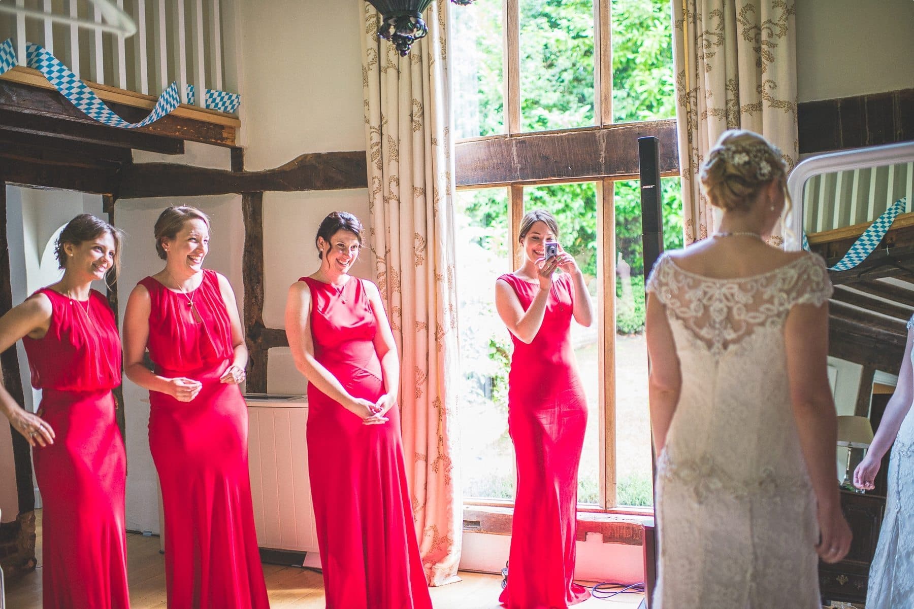 Bridesmaids looking and smiling at the beautiful bride at Coworth Park barn Dower House