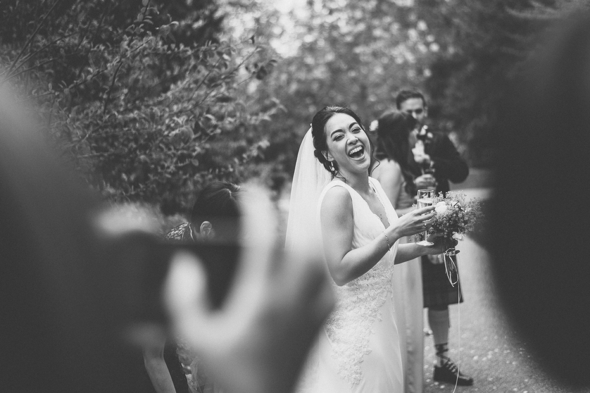 Bride laughing at her guests as they take photos of her at her Two Temple Place Wedding