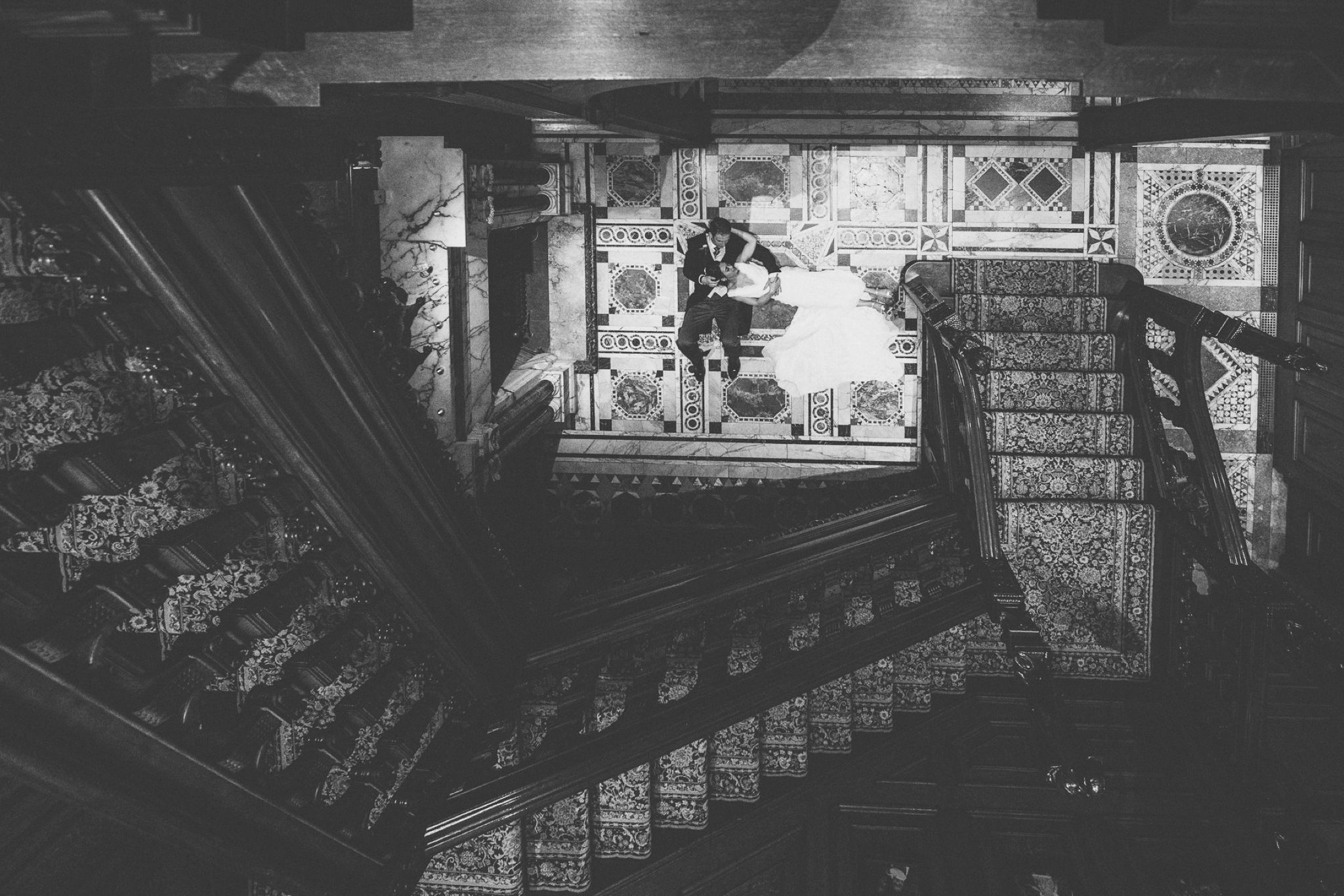 Bride and Groom lying at the bottom of Two Temple Place stairs and gallery