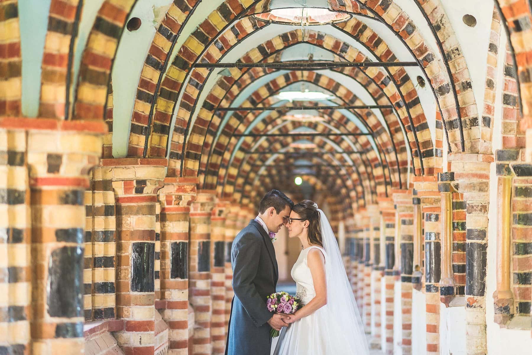 Bride and groom framed by Horsley Towers arches