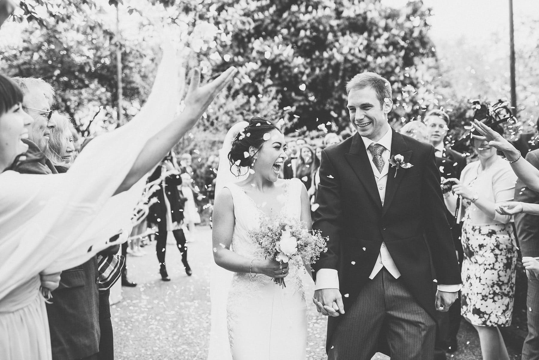 bride and groom walking through their wedding confetti