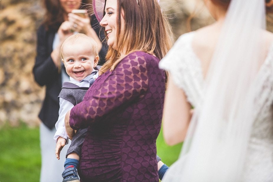 Baby smiling at the bride at her Hedingham Castle Wedding