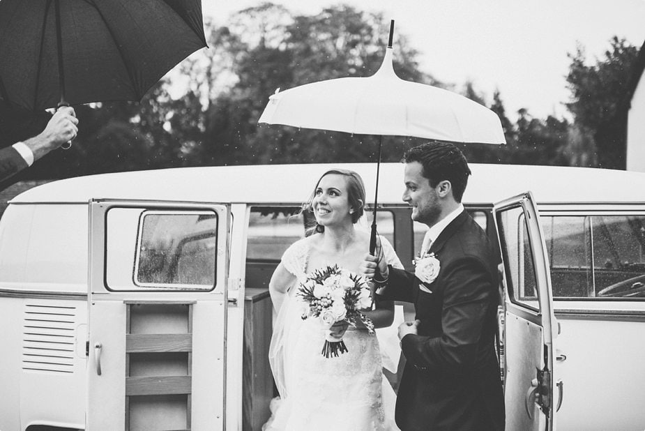 Bride and groom arriving in their VW van at their Smeetham Hall Barn rustic rainy wedding