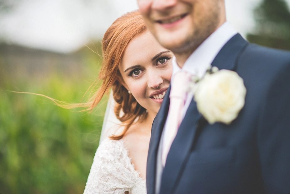 Bride looking past groom's shoulder at their Smeetham Hall Barn rustic rainy wedding