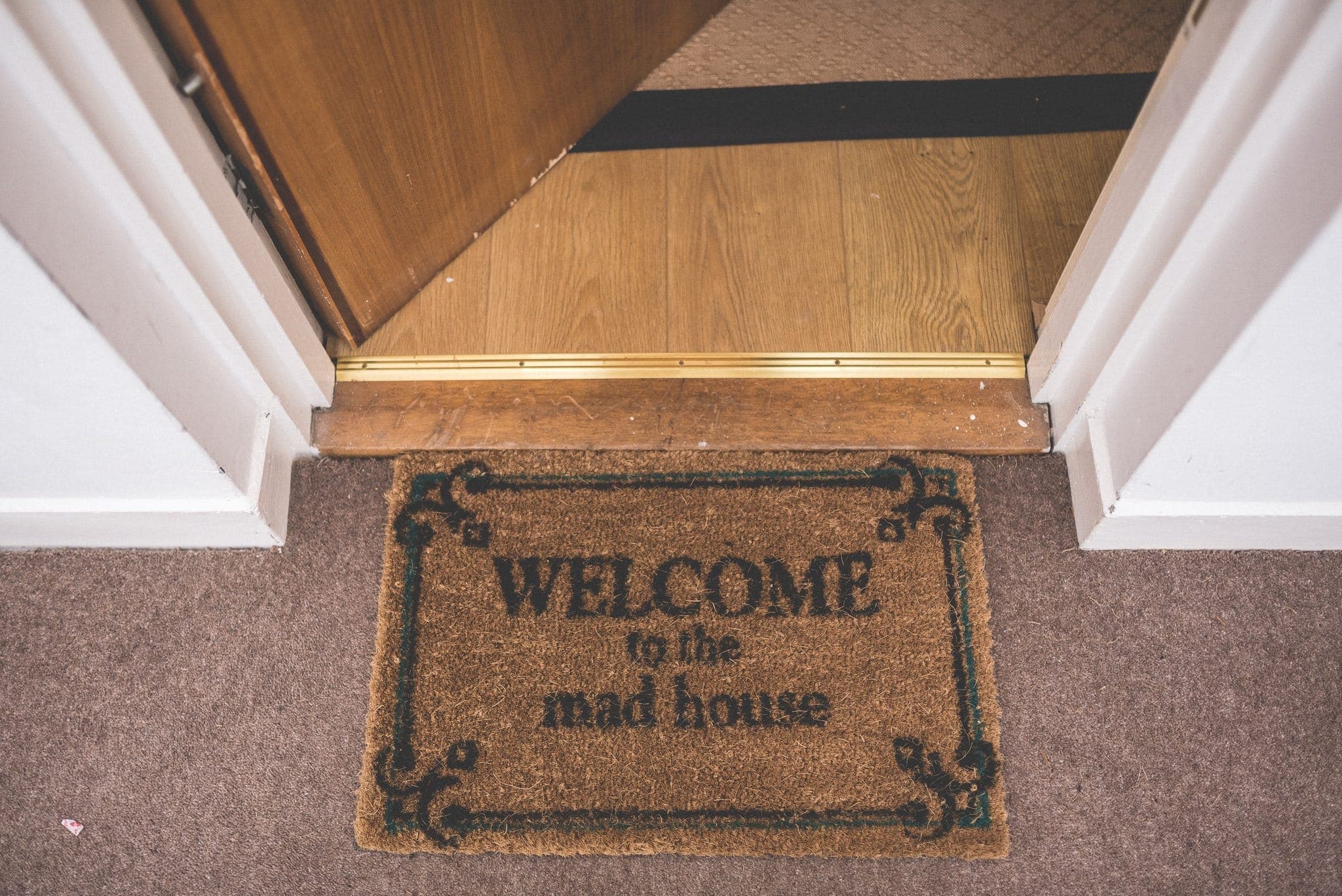 Door mat saying welcome to the mad house