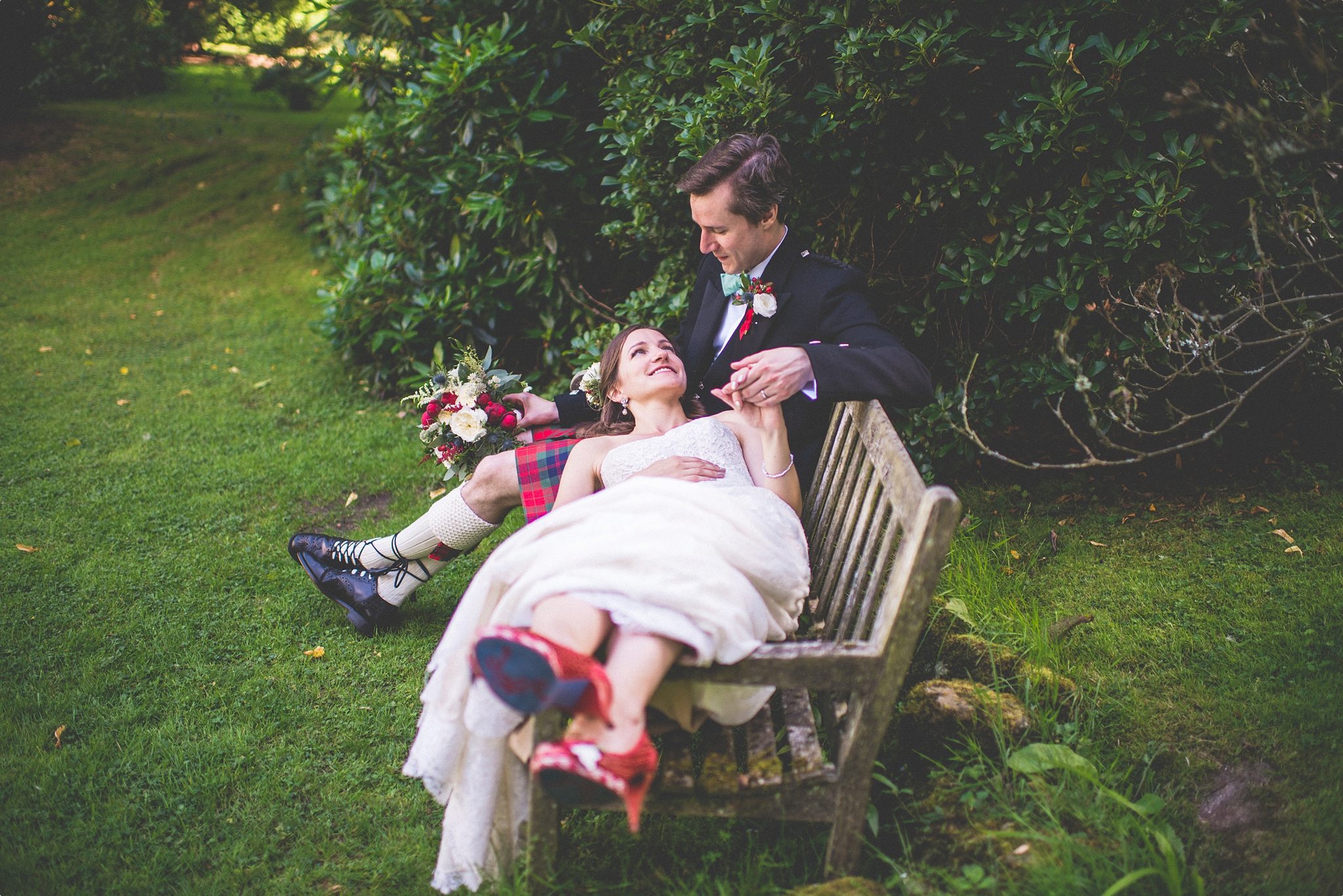 Bride and groom relaxing on a bench at the Elvetham Hotel