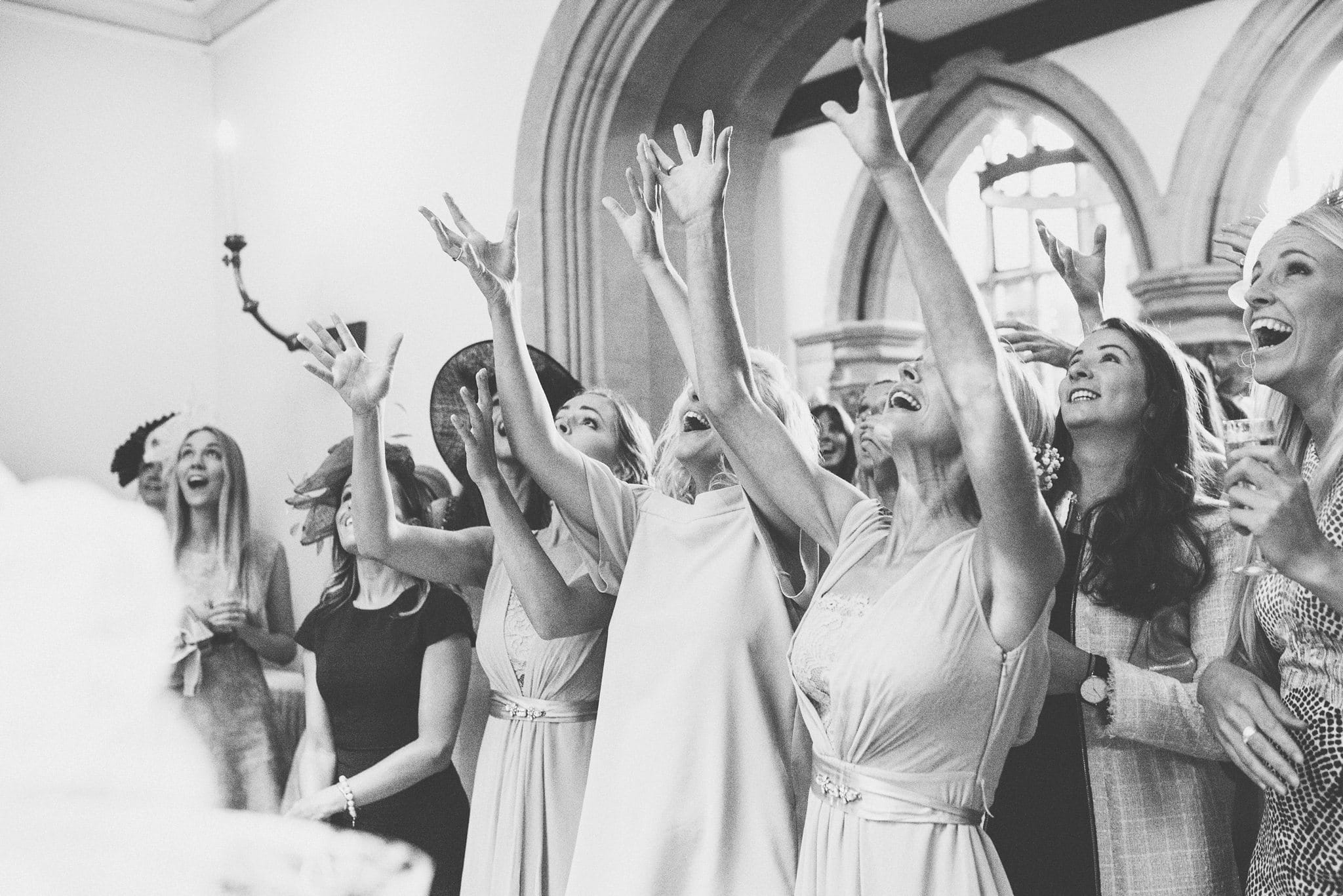 Girls jumping to catch the wedding bouquet at St Audries Park