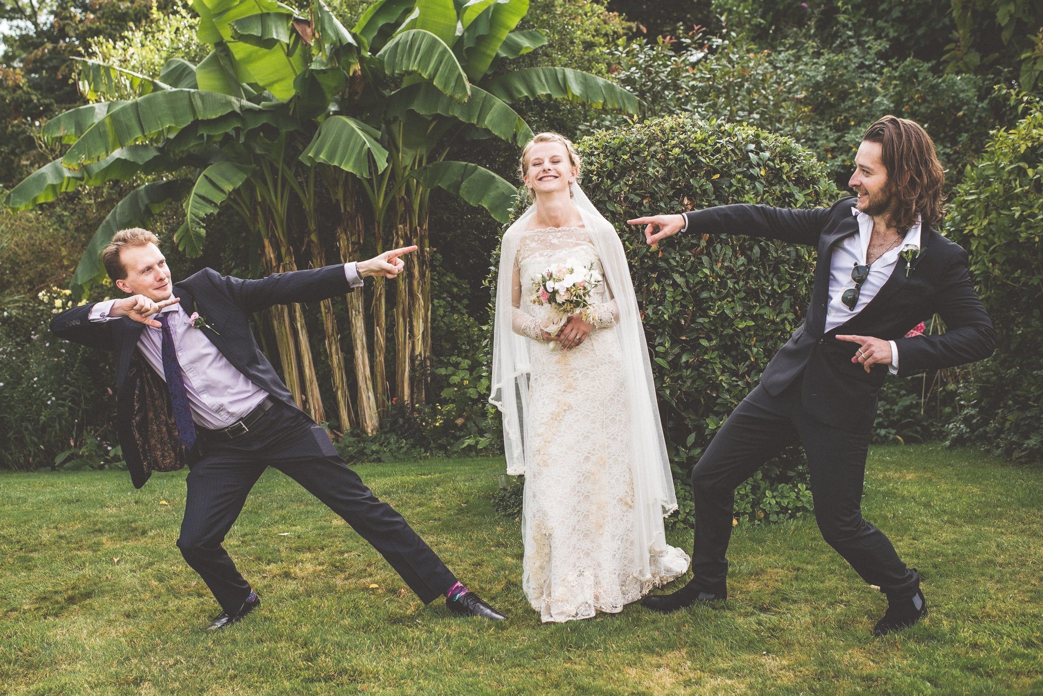 Bride strikes a pose with her brothers at her Smedmore House Romantic Seaside Wedding