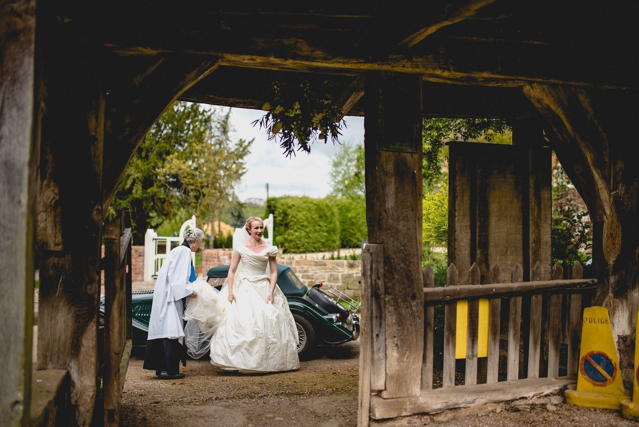 Bride Hatty is greeted by the vicar as she exits her vintage car at the church