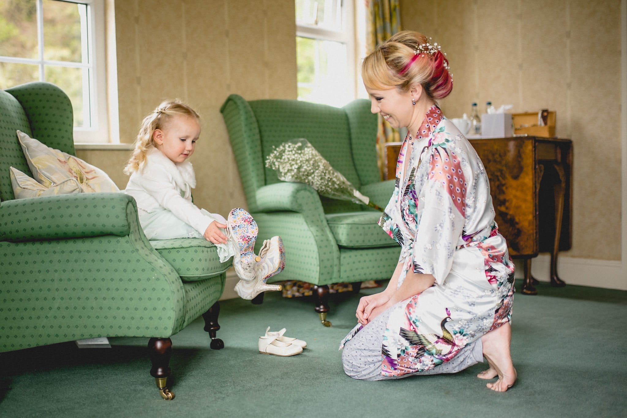 Bride's daughter puts on her mum's bridal shoes prior to her Quirky Birtsmorton Court Wedding