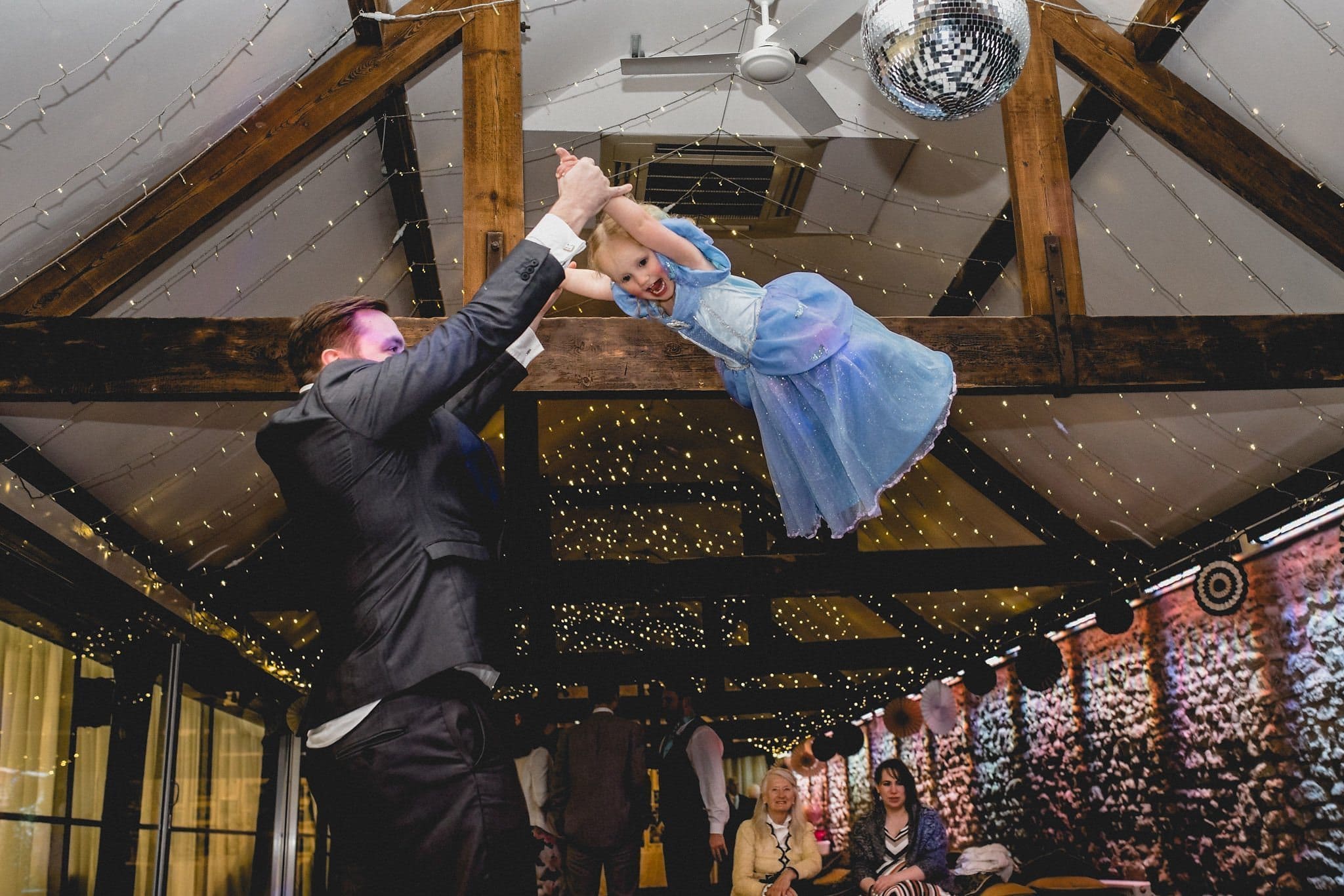 One of the children is swung high into the air on the dancefloor at Birtsmorton Court