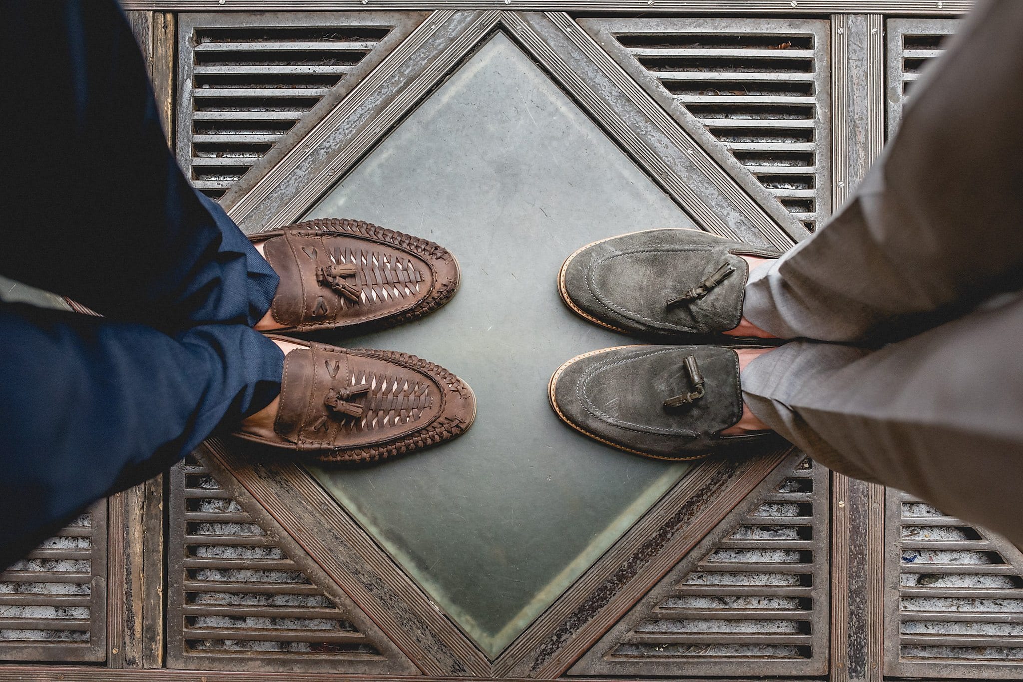 Two grooms' loafers face each other from above on a diamond-patterned tile at København Rådhus