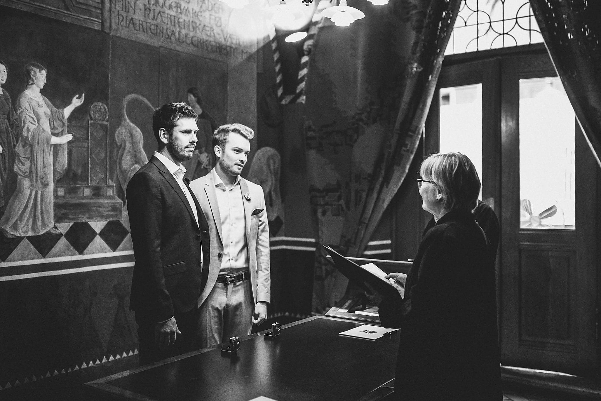 Two grooms listen to the registrar during their Copenhagen marriage ceremony