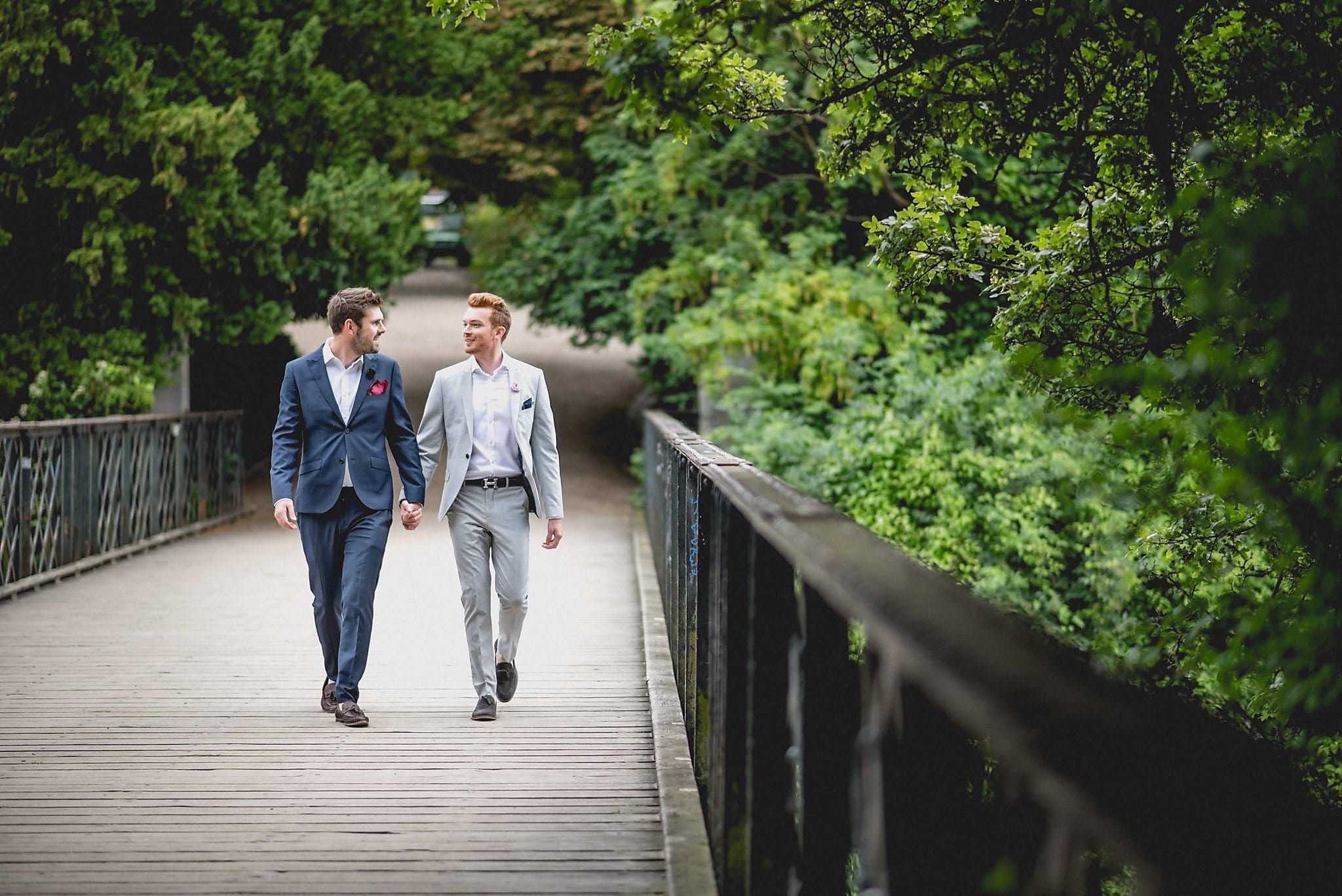 Same-sex couple walk hand in hand across the bridge in Ørstedsparken, Copenhagen