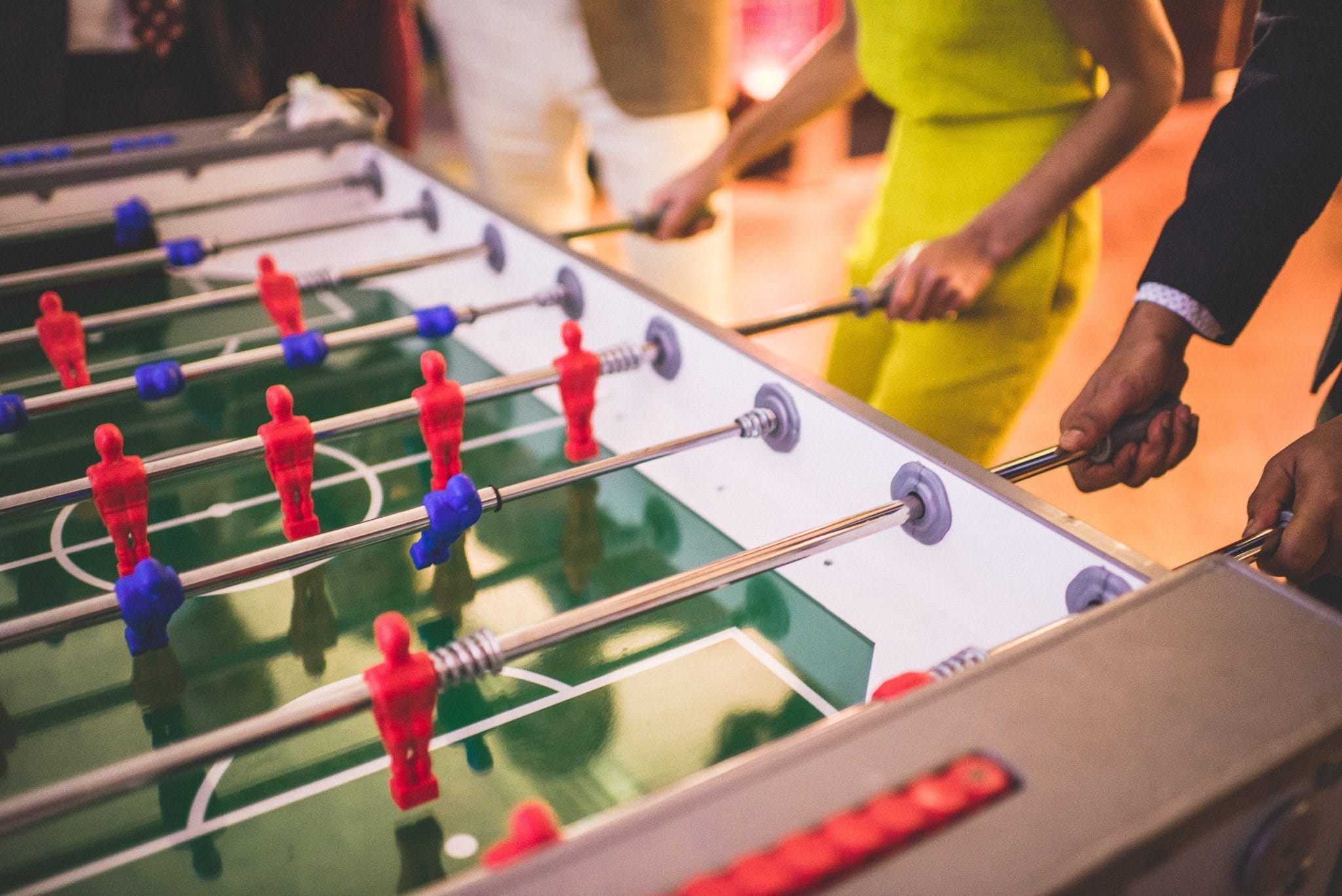 A close up of a cut-throat table football match being played at the reception venue