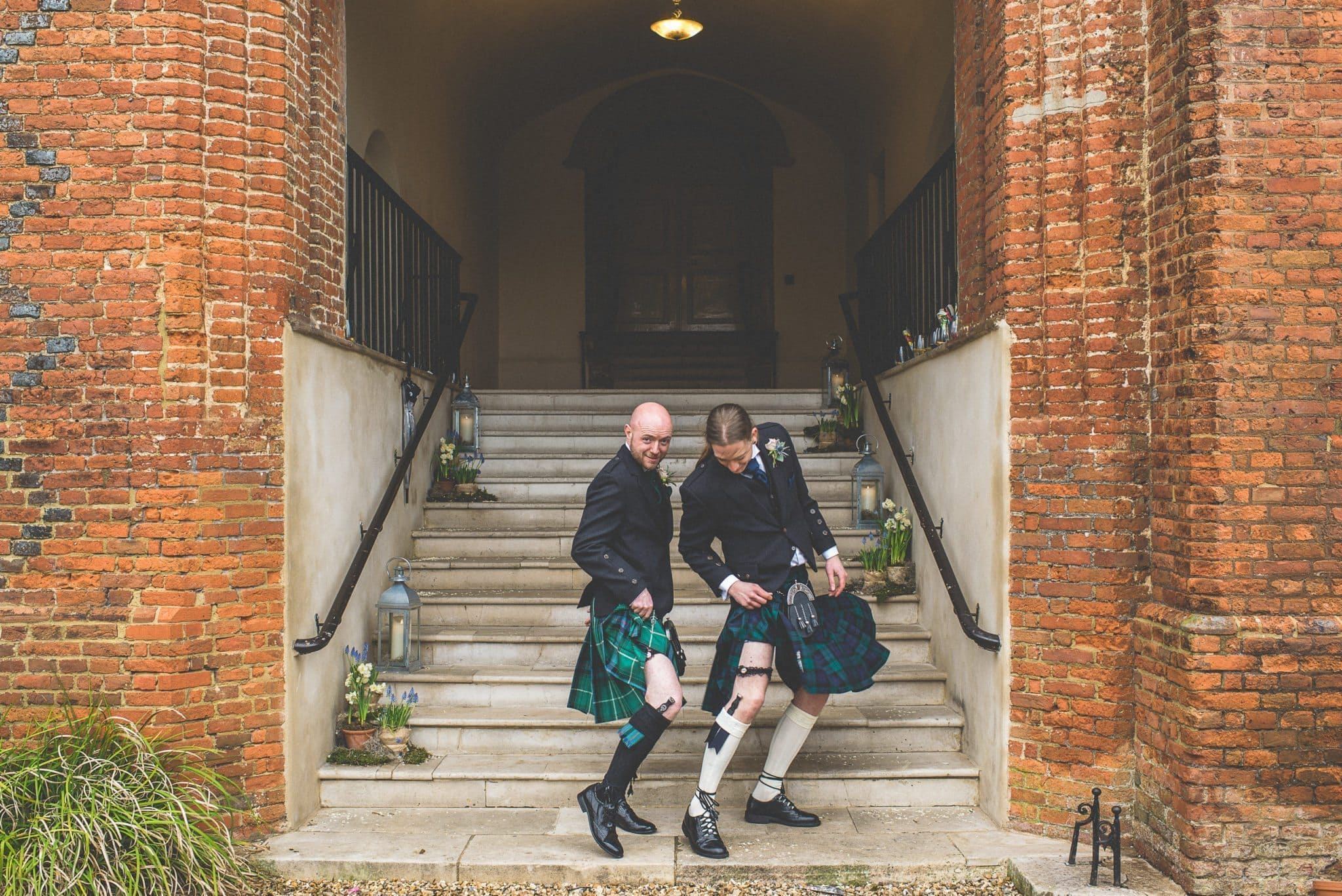 The groom and his best man strike a silly pose, and show off their snazzy knee socks.