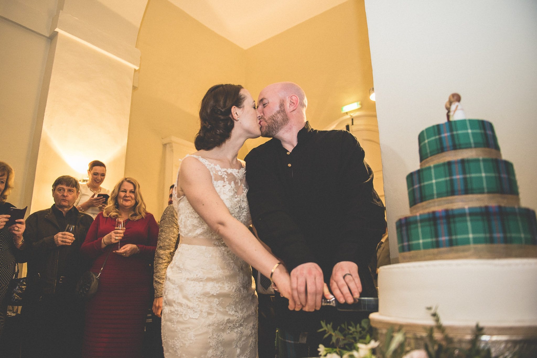 Bride and Groom cutting their scottish tartan cake at Farnham Castle